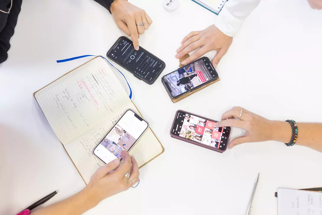 Vue en hauteur d'une table sur laquelle 4 smartphones sont utilisés